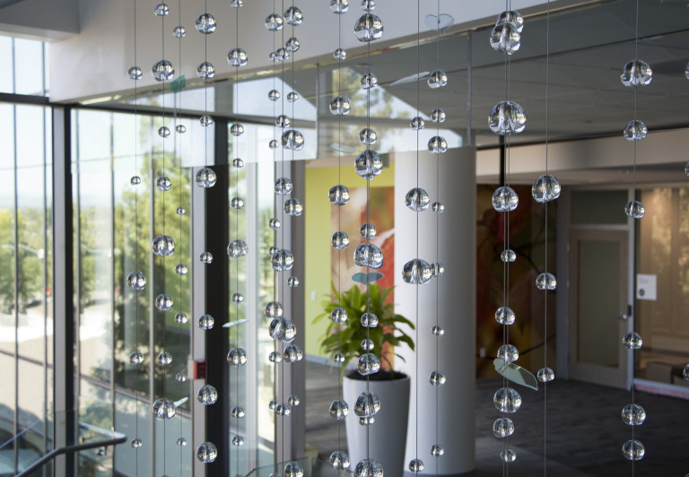 Hand-sculpted glass and dichroic glass suspended on stainless steel cables