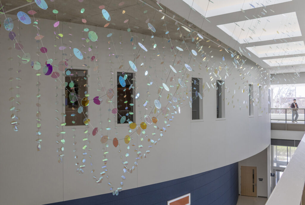 Glass suspended sculpture with 2,000 dichroic glass flower petals and leaves inside Steven Wymer Hall, University of Illinois Urbana-Champaign